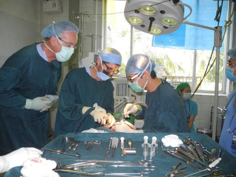 Dr Scott Armstrong & local trainee Dr Sandeth Phan operating under supervision in Phnom Pen